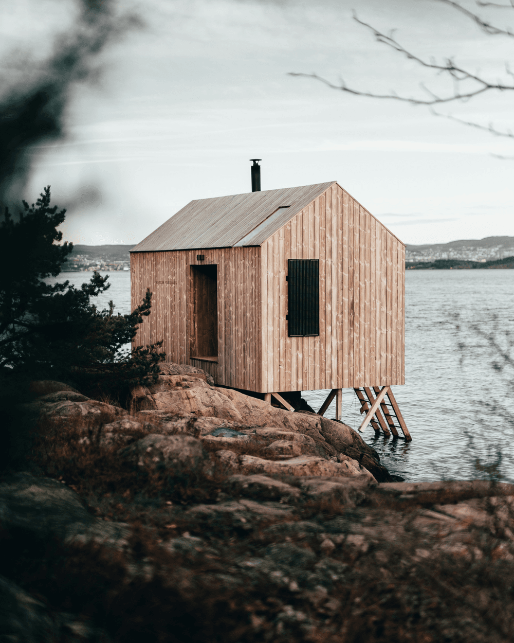 Modern wooden sauna cabin by the water